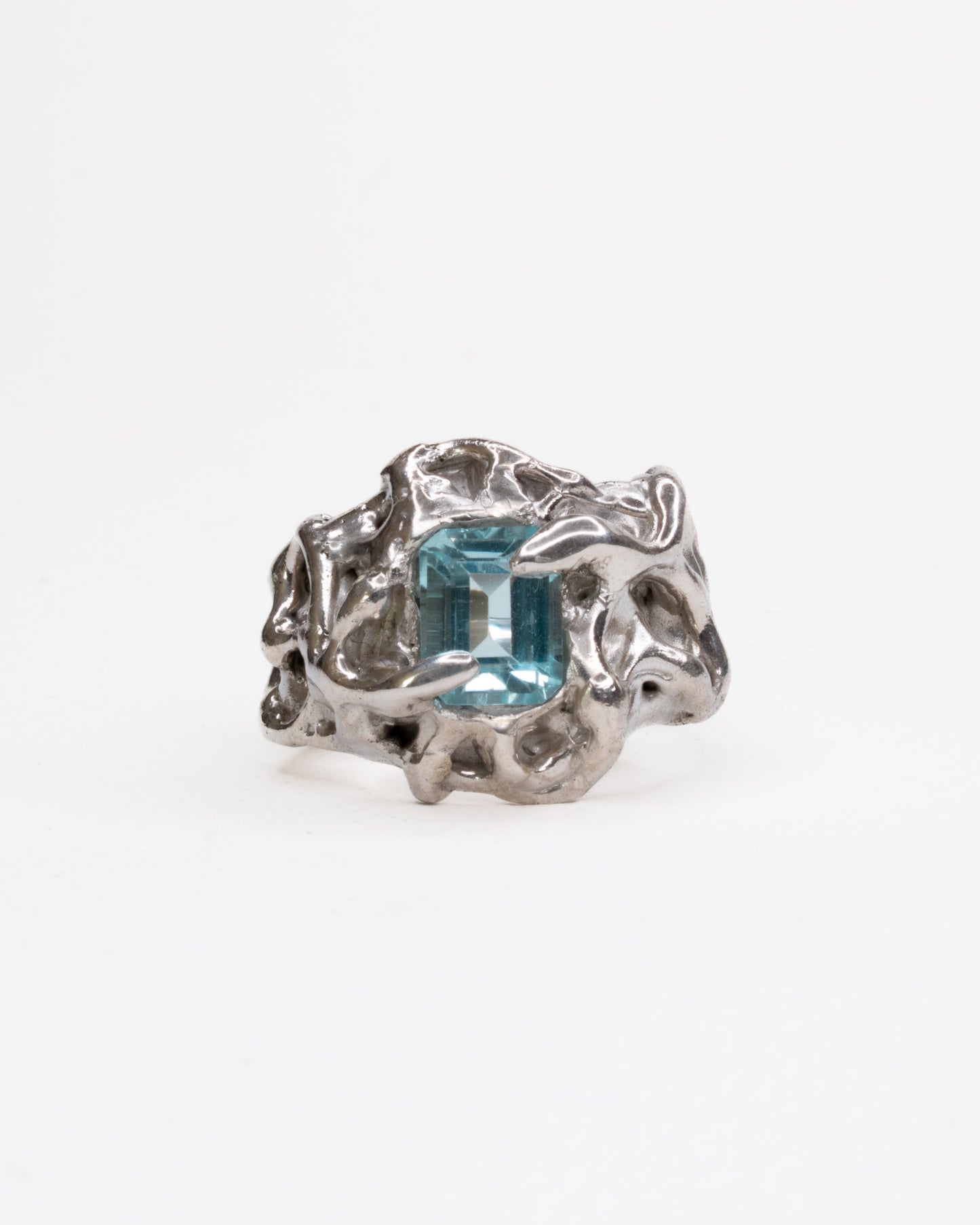 Silver ring with a blue gemstone on a white background