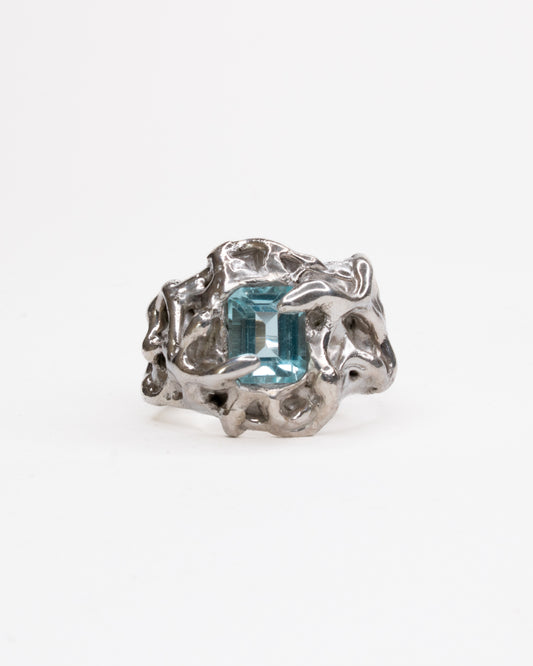 Silver ring with a blue gemstone on a white background